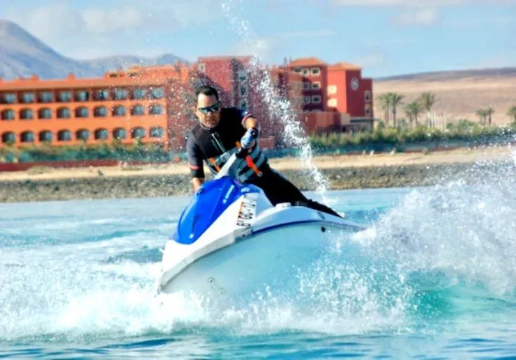 Jet ski jumping over waves in front of the hotels of Caleta de Fuste