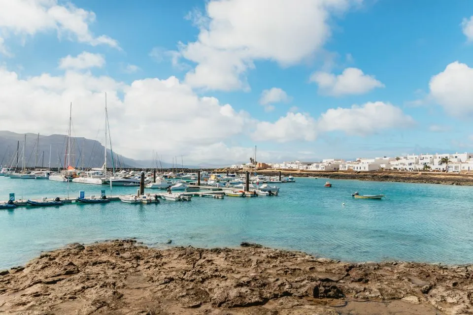 Caleta del Sebo on La Graciosa seen from the water, with the Risco de Famara cliffs behind